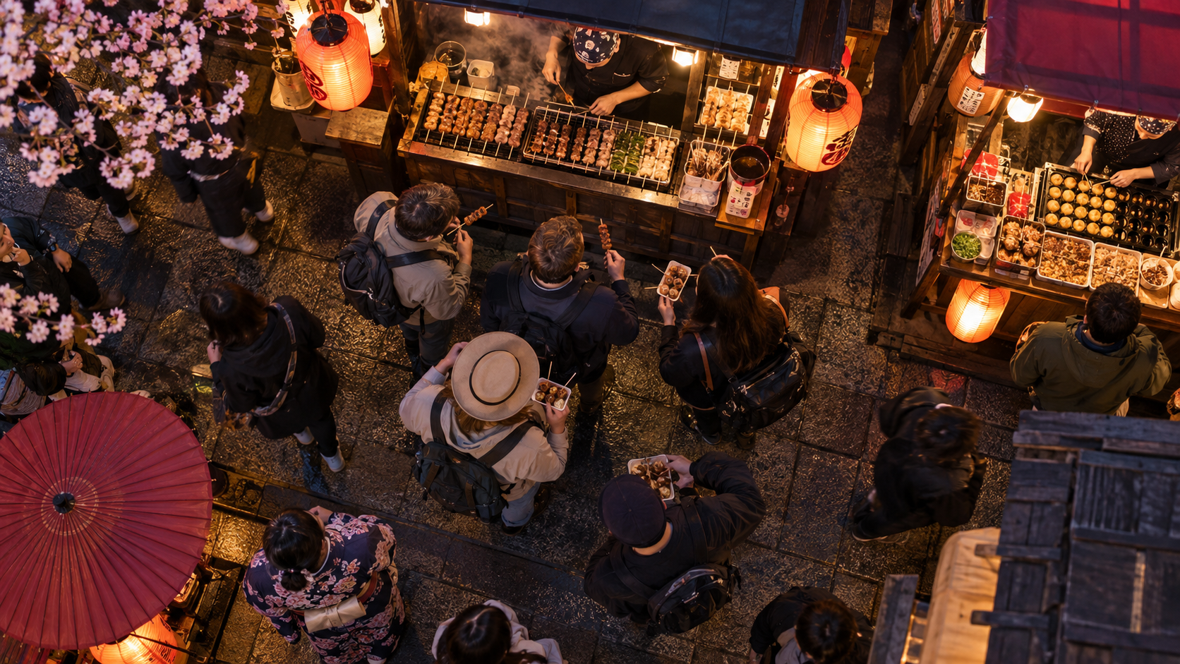 Overhead view of travellers sharing food at Japanese night-market stalls